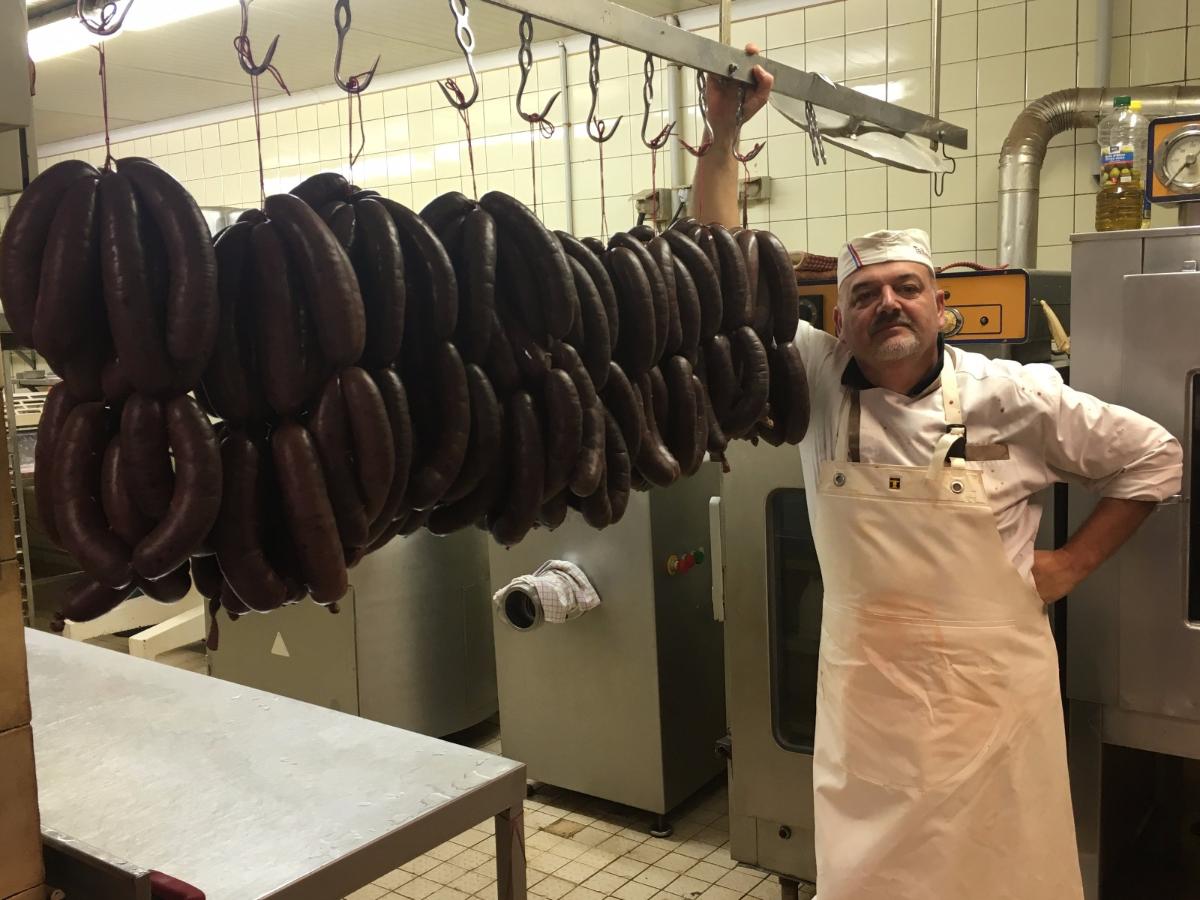 Une personne à côté de boudins noirs qui pendent 