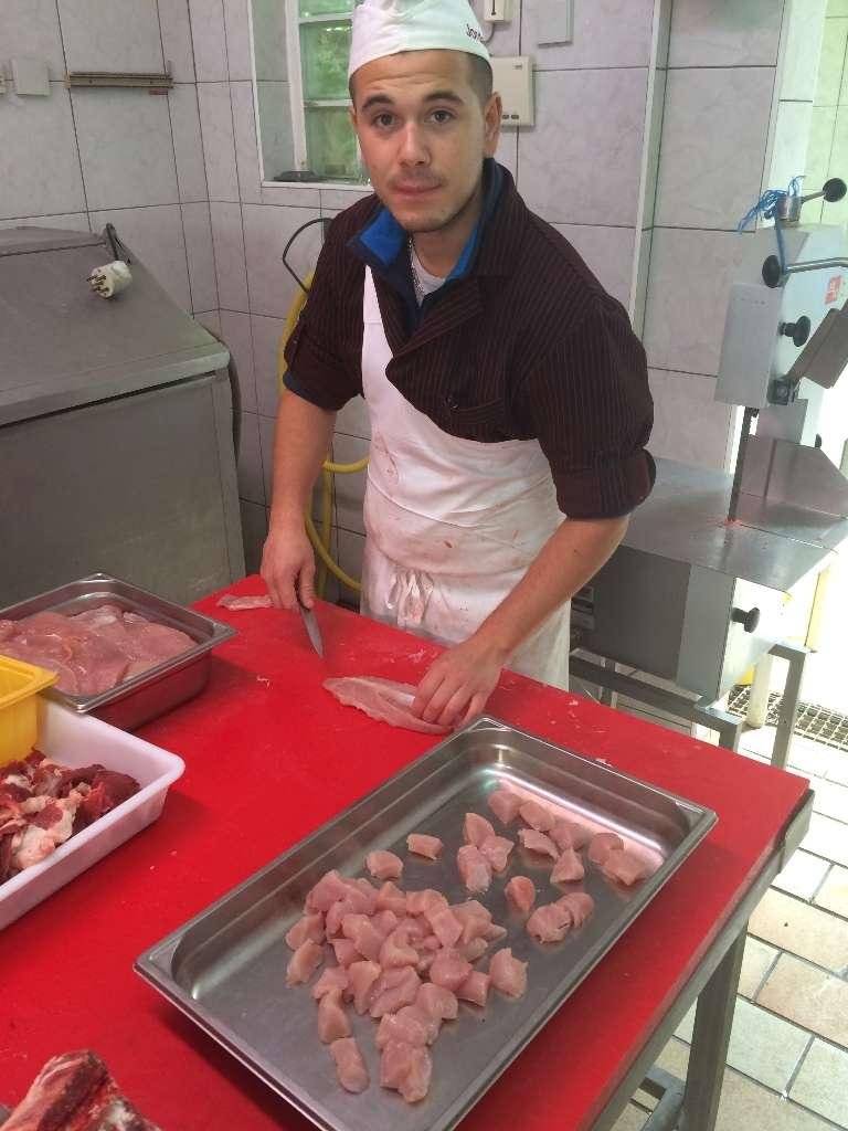 Une personnne qui découpe des morceaux de viande