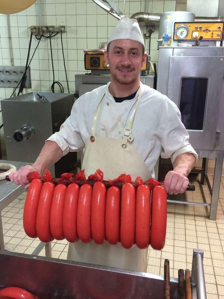 Une personne qui tient des saucisses de viande