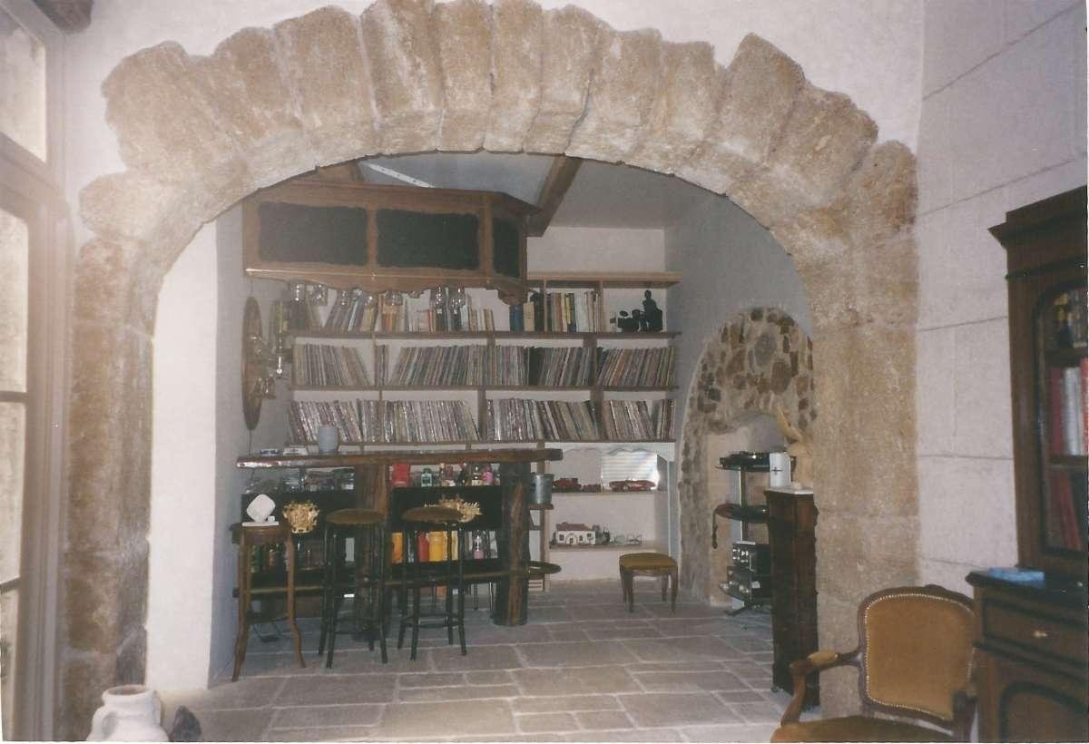 Salon d'un intérieur de bâtiment en pierre rénové des murs au sol en passant par l'aménagement