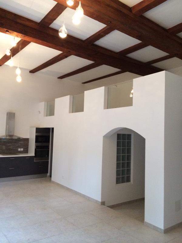 Rénovation achevée en intérieur de bâtiment avec mezzanine sous un toit avec poutres apparentes