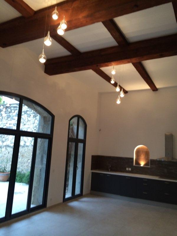 Projet de rénovation immobilière en murs et plafonds avec poutres apparentes et luminaires suspendus