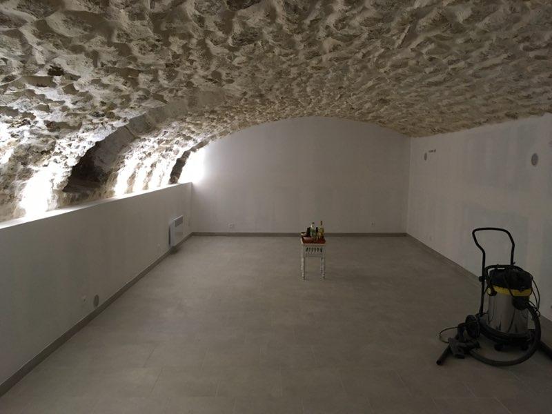 Intérieur d'un bâtiment rénové avec pierres apparentes au plafond et sol nettoyé