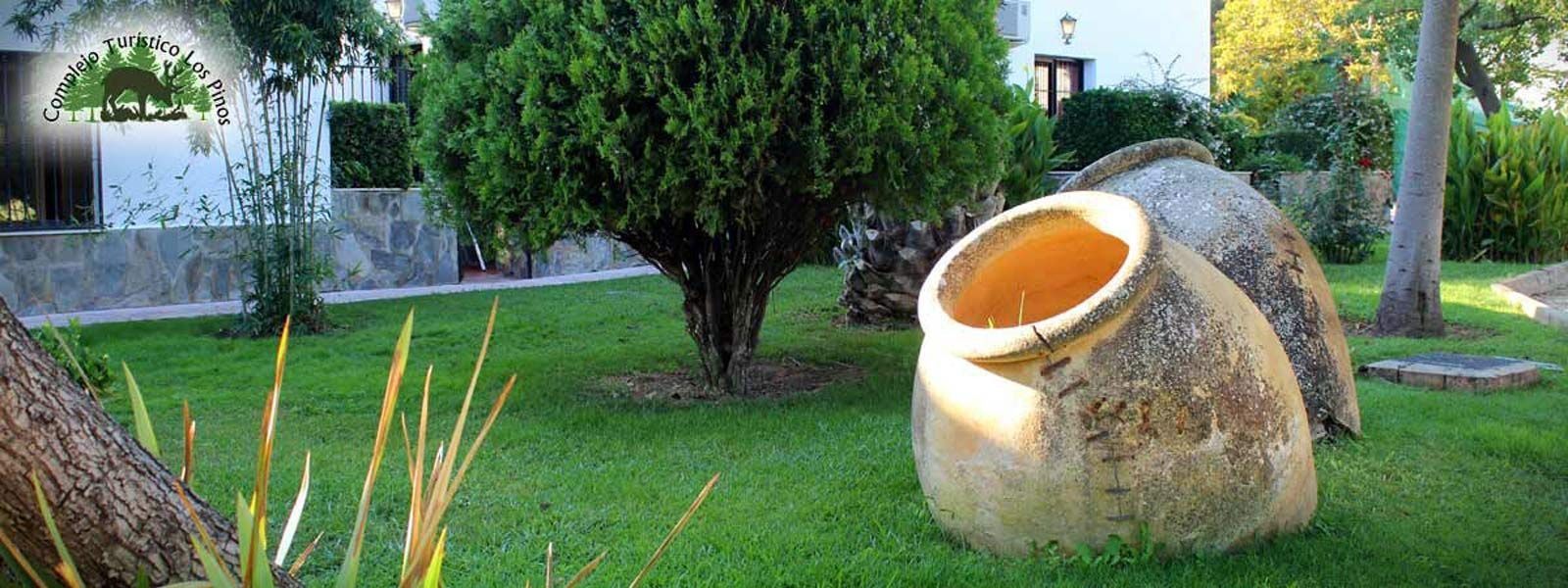 Una maceta grande está en el césped de un jardín.