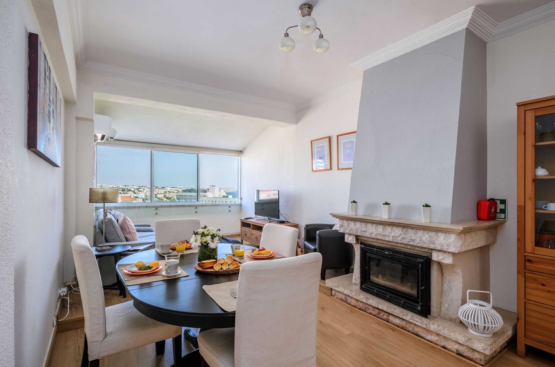 A dining room with a table and chairs and a fireplace.