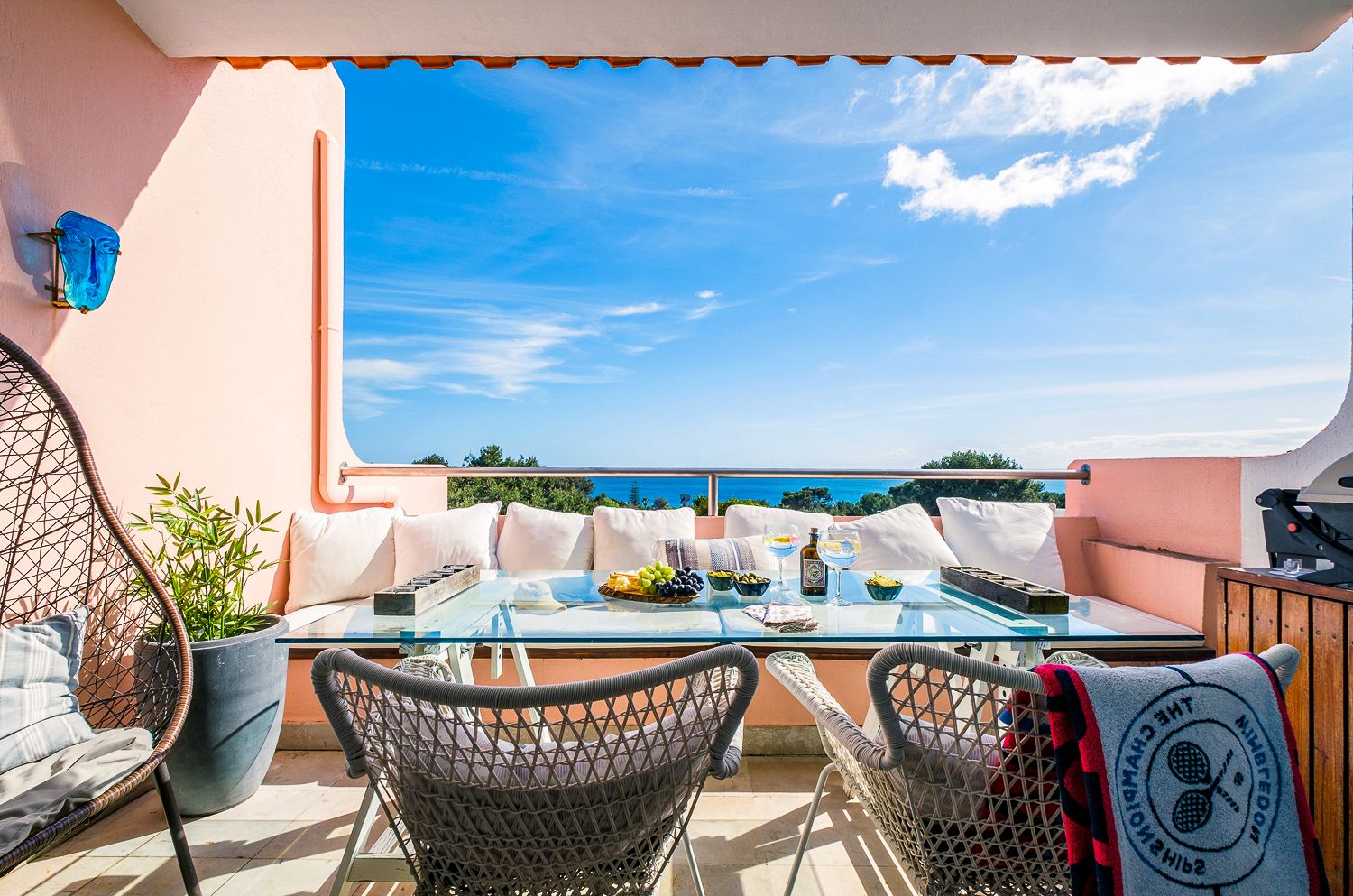 A balcony with a table and chairs and a view of the ocean.
