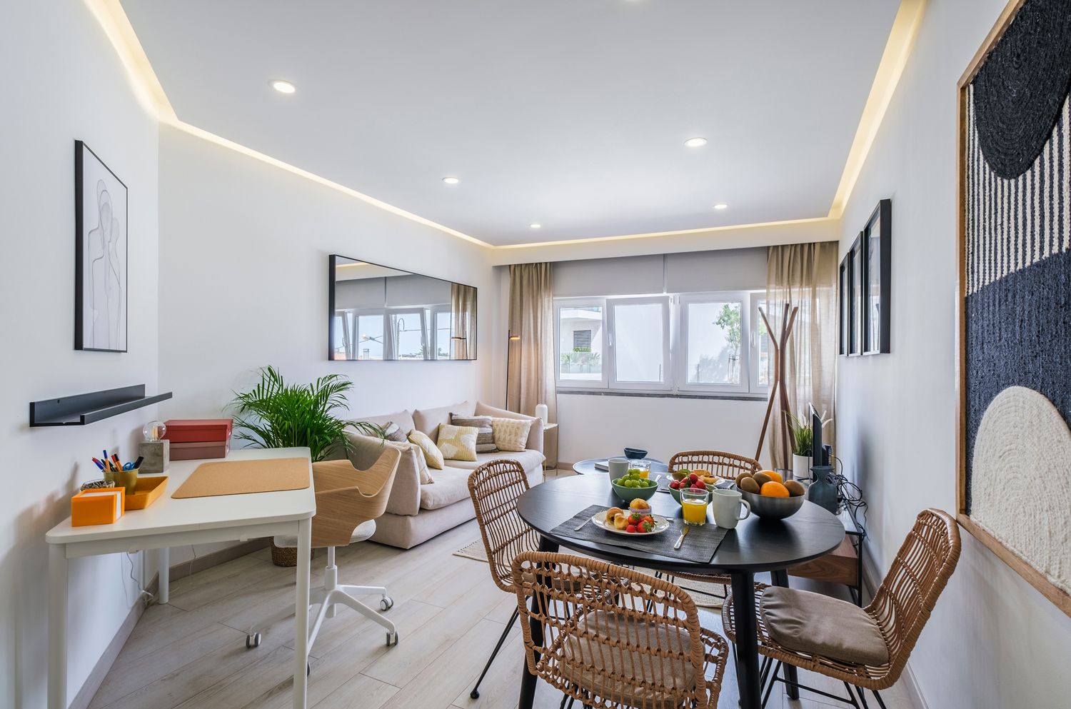 A living room with a table and chairs and a couch.