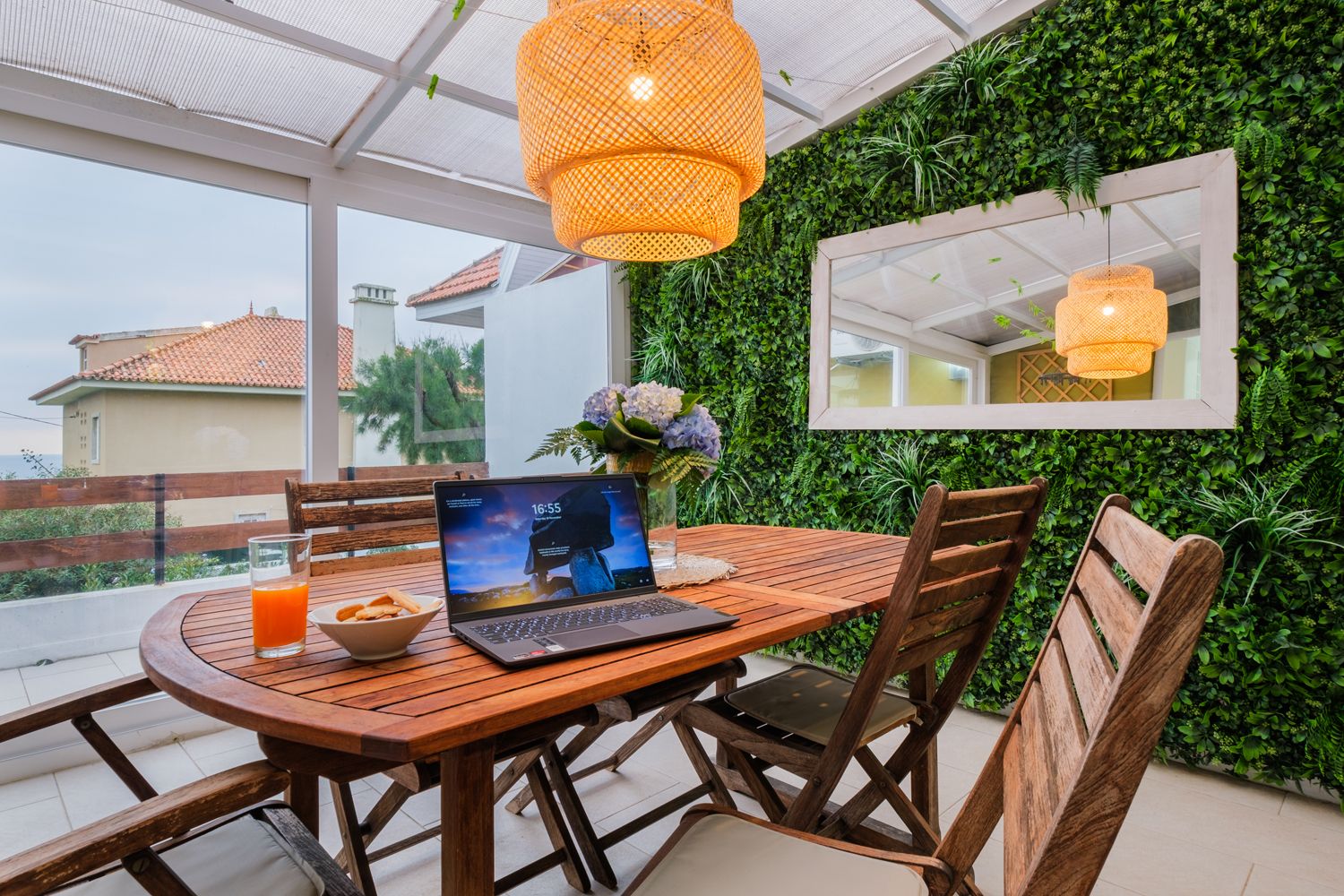A laptop is sitting on a wooden table in a dining room.