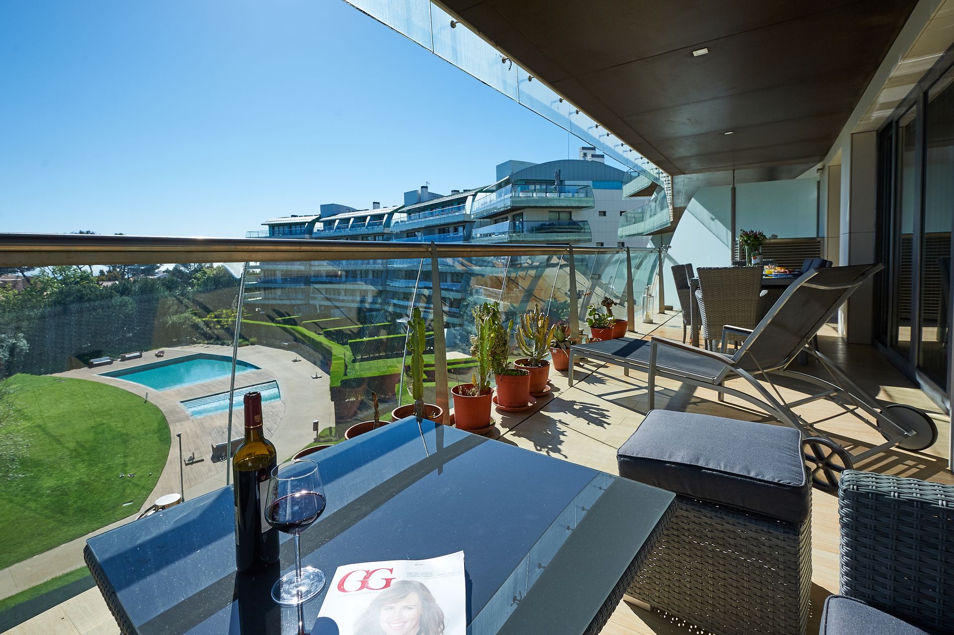 A balcony with a table and chairs and a bottle of wine on it