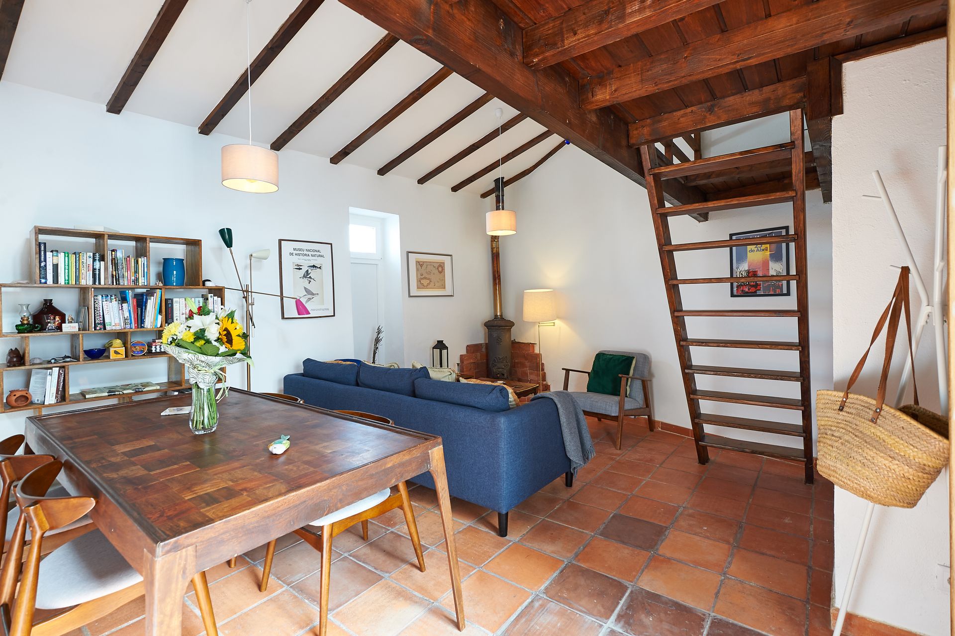 A living room with a blue couch and a wooden table