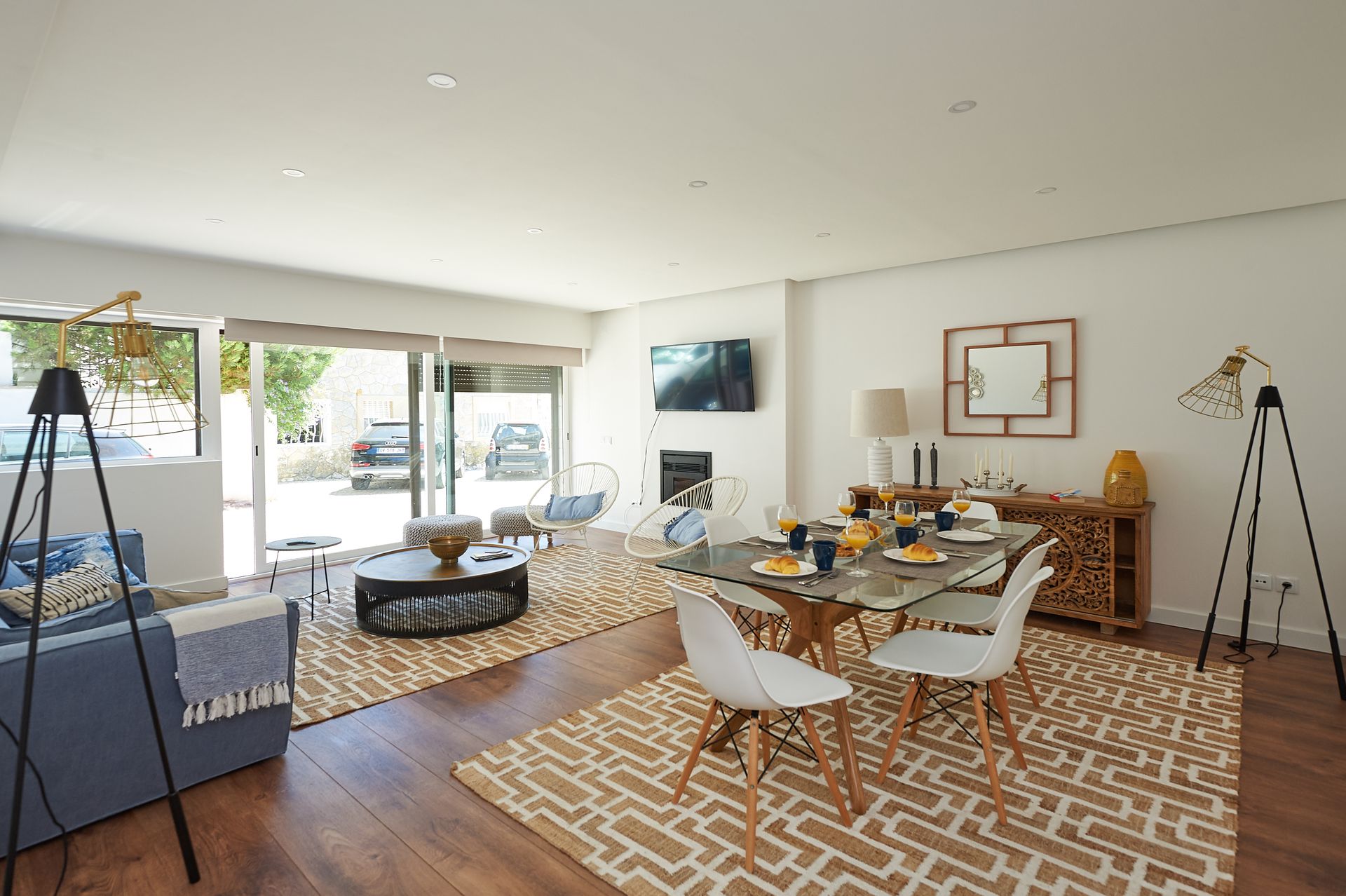 A living room with a dining table and chairs and a television.