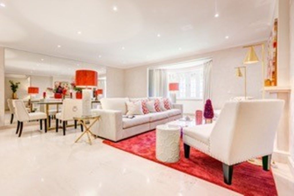 A living room filled with furniture and a red rug.