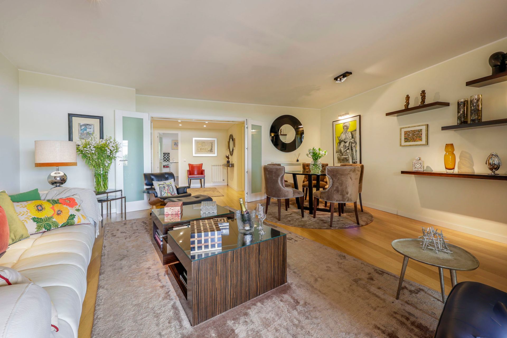 A living room with a couch , coffee table , chairs and a dining table.
