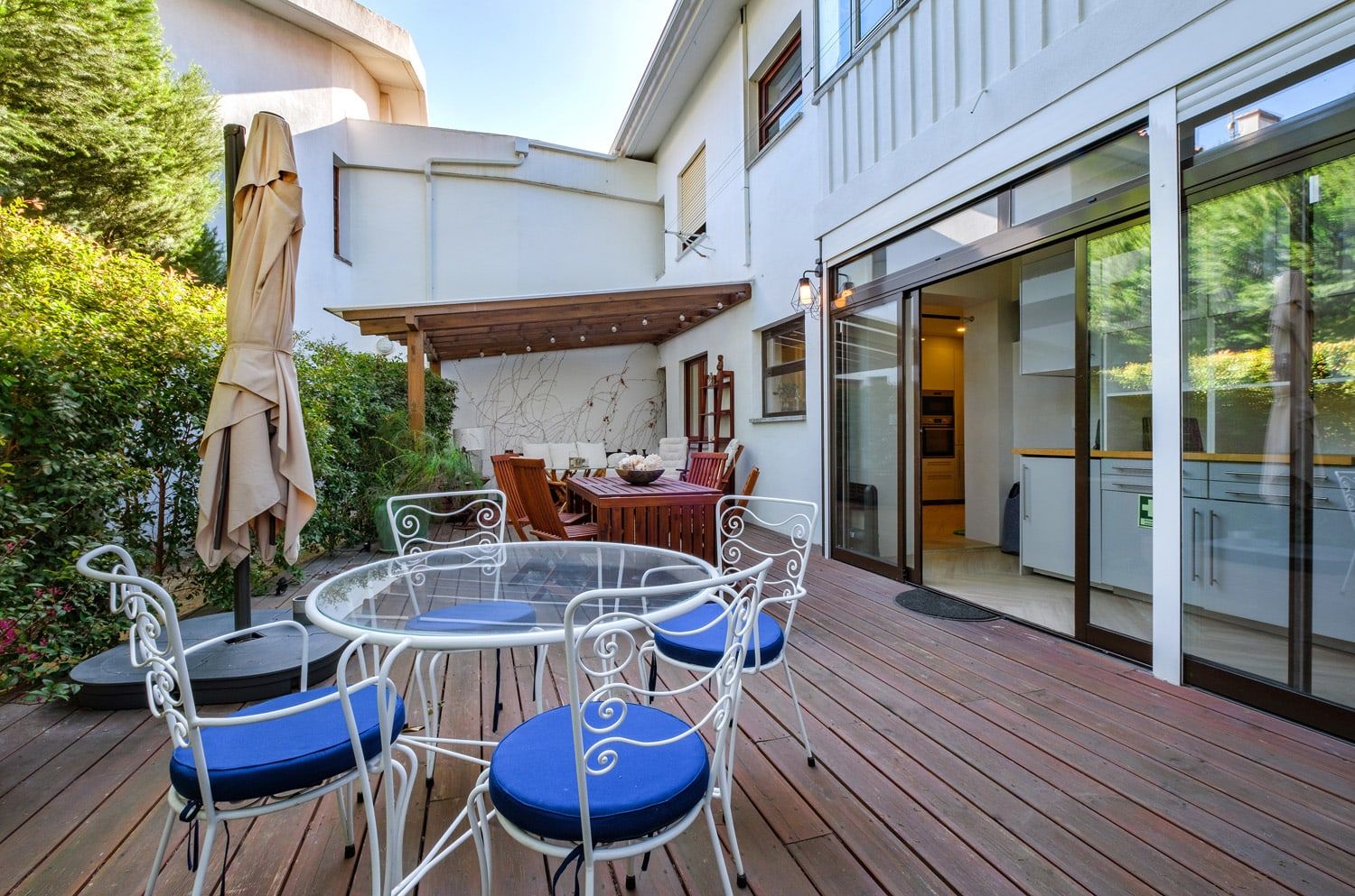 There is a table and chairs on the deck of a house.