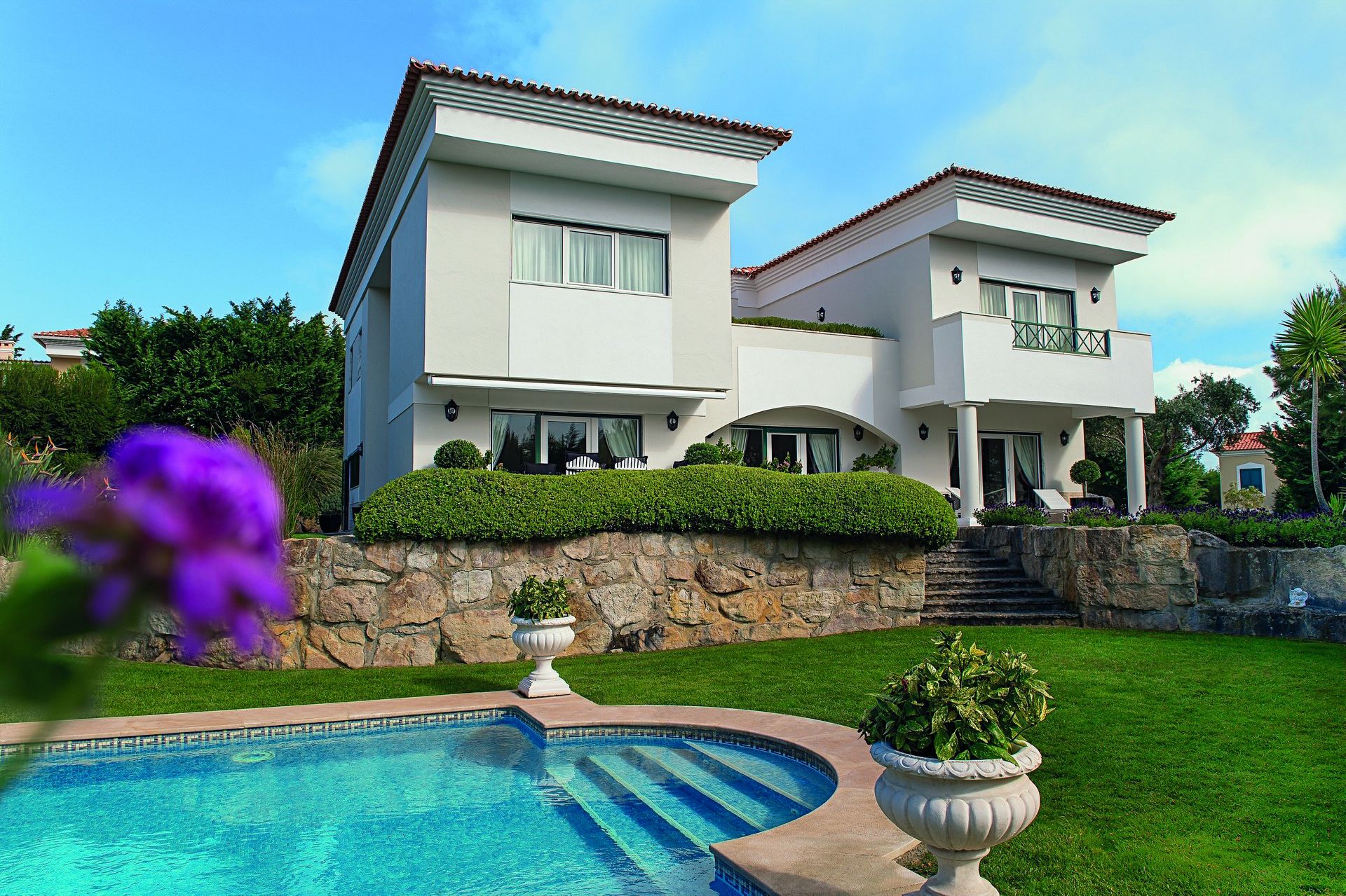 A large white house with a swimming pool in front of it