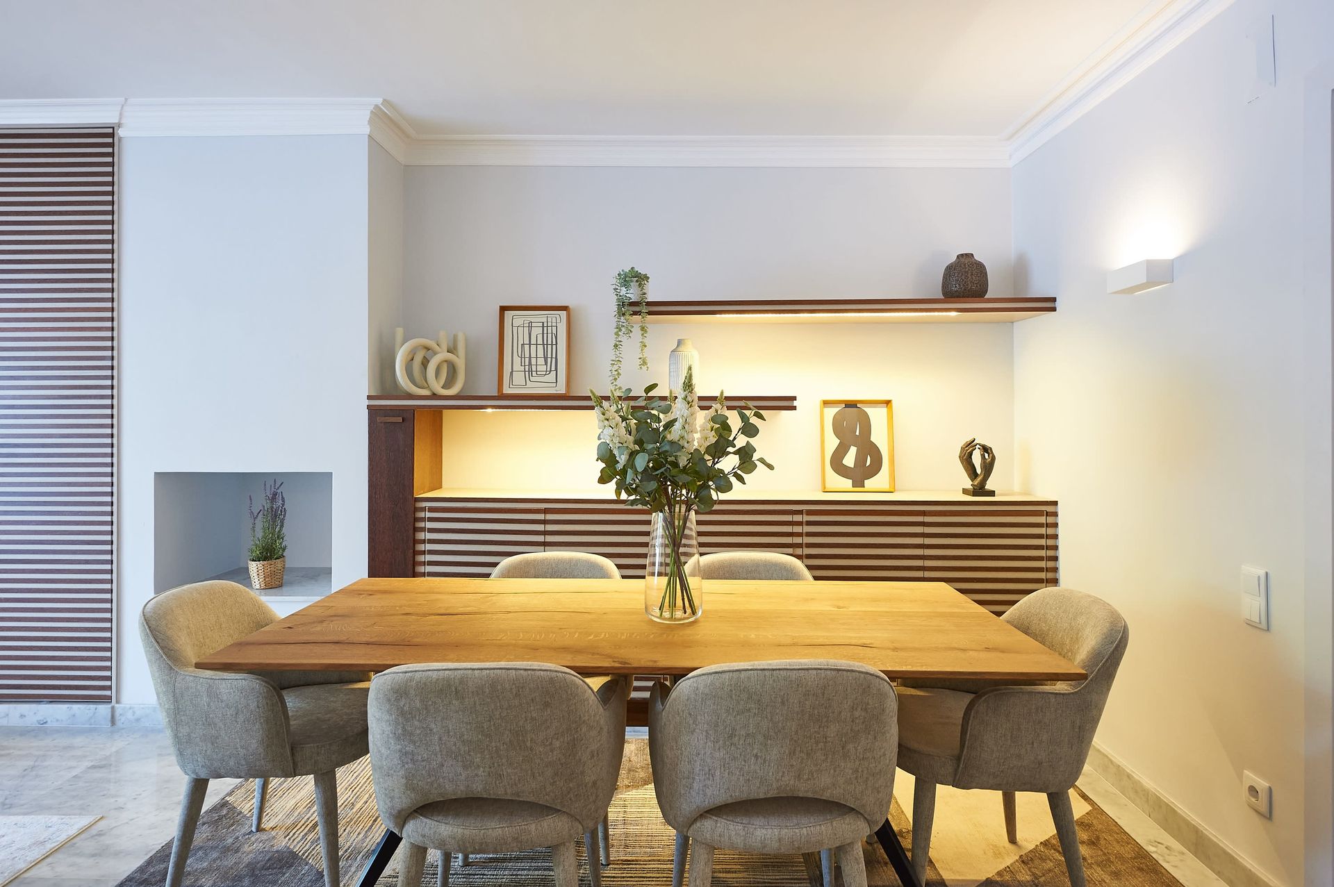 A dining room table with a vase of flowers on it