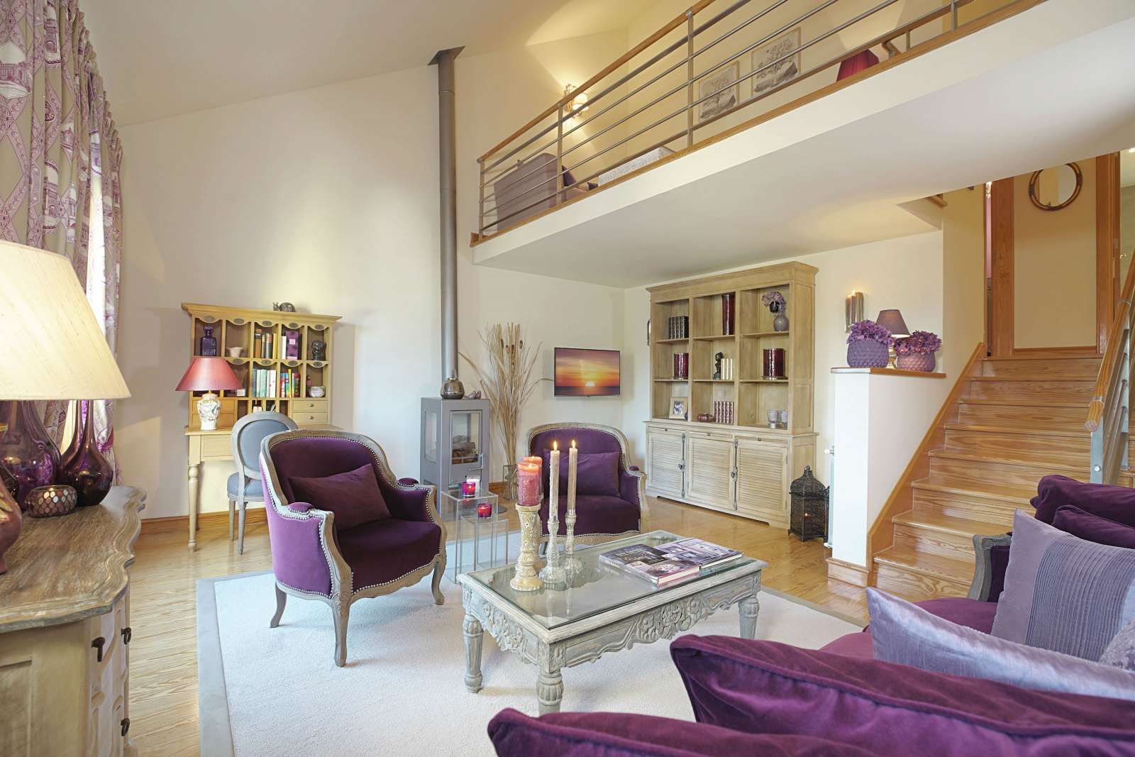A living room with purple furniture and a balcony