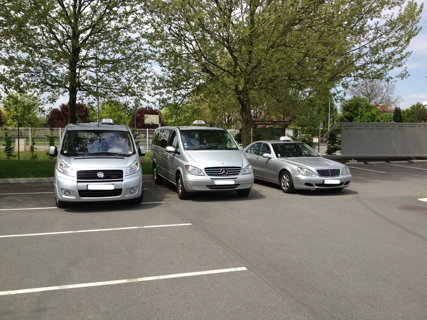 Vue de biais de trois taxis de différentes tailles : 2 Mercedes et 1 Dacia
