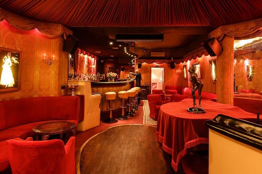 Ein großer Raum mit roten Tischen und Stühlen und einer Statue auf dem Boden.