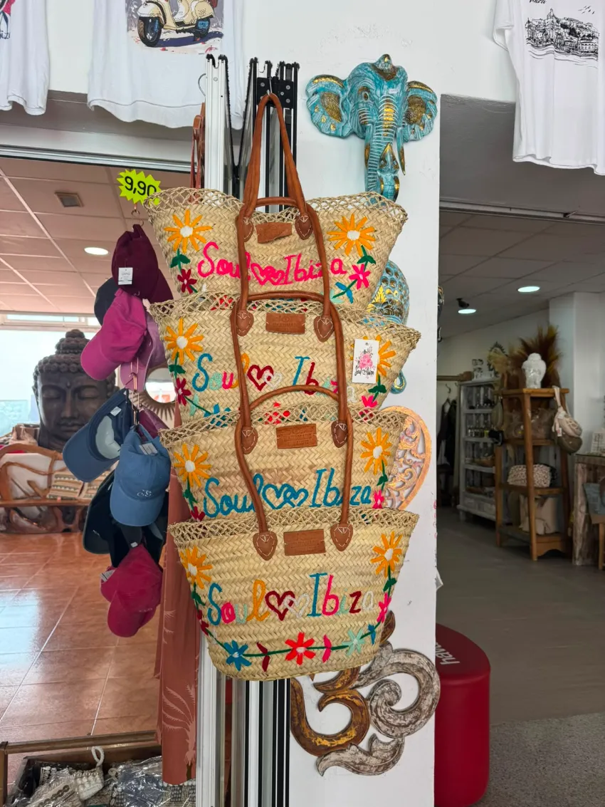 Adorno colgante tejido y colorido con cuentas y flores, expuesto en el pasillo de una tienda.