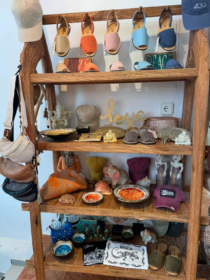 Estantería de madera con pequeños zapatos de arcilla y objetos decorativos en miniatura, creando una acogedora vitrina.