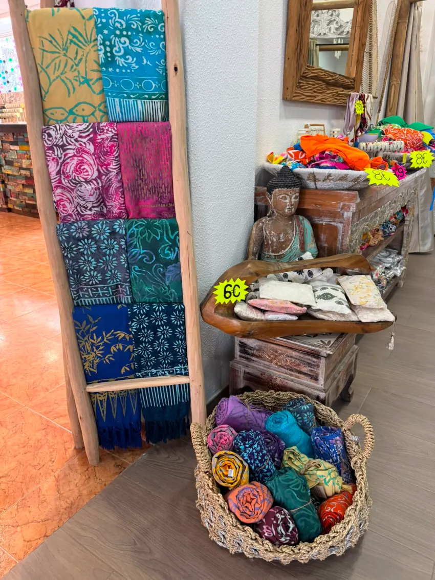 Textiles tejidos y cestas de colores expuestos en el pasillo de una tienda.