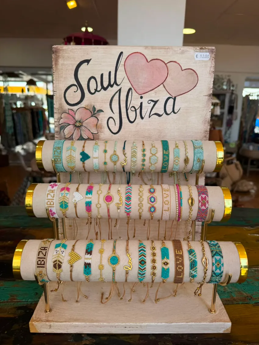 Letrero decorativo “Soul Ibiza” con varillas apiladas con estampado floral y un corazón rosa, en un escaparate.