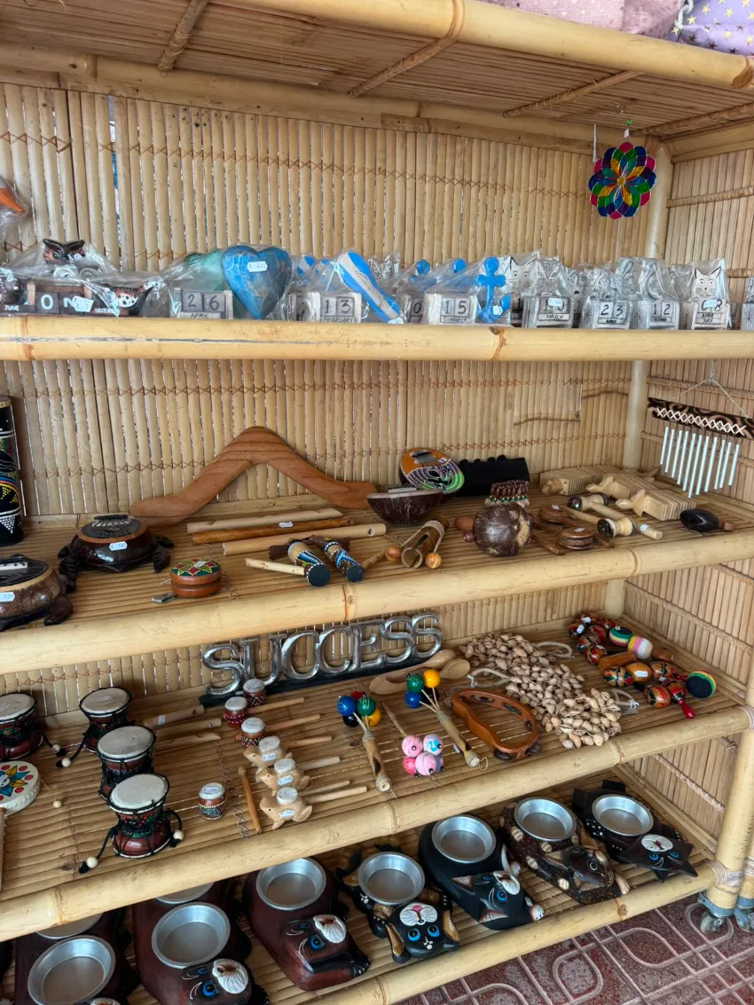 Estanterías de madera que exhiben cerámica artesanal, cuencos y objetos decorativos en una tienda rústica.