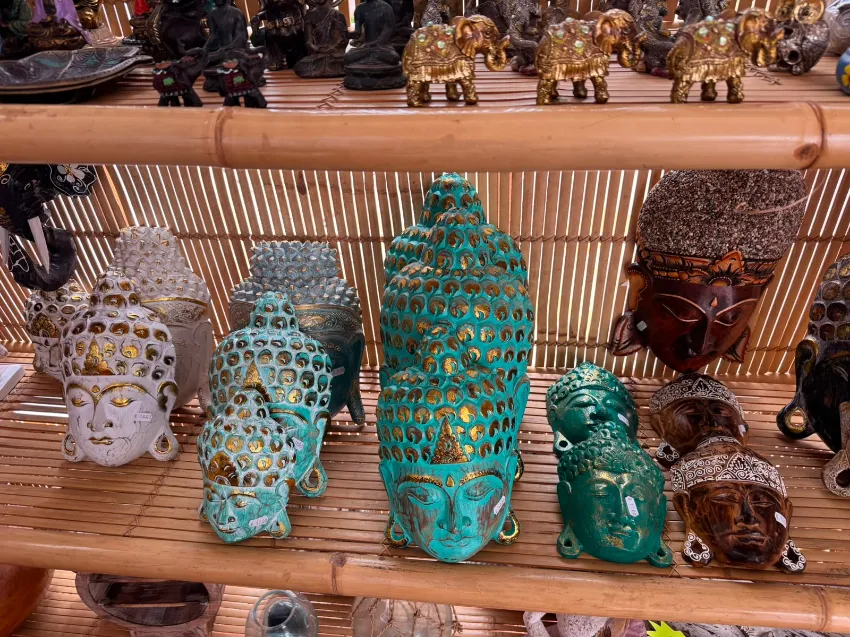 Surtido de figuritas decorativas de animales de cerámica en tonos turquesa, blanco, marrón y dorado sobre un estante.
