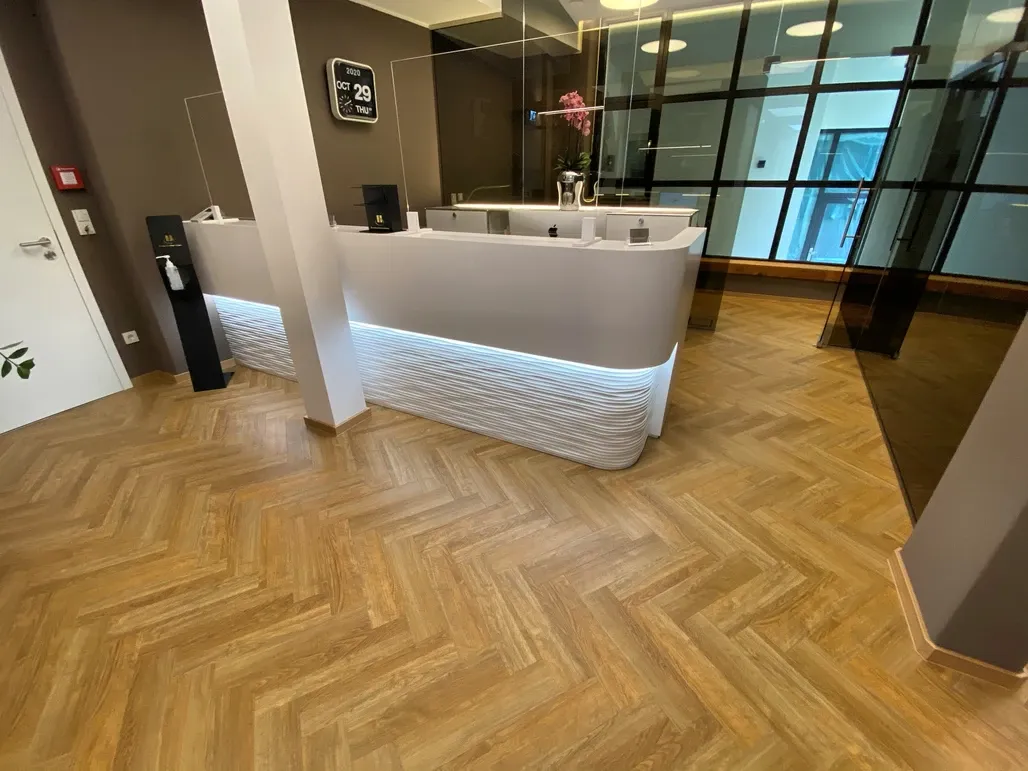 Ein Raum mit einem Holzboden und einem weißen Schreibtisch.