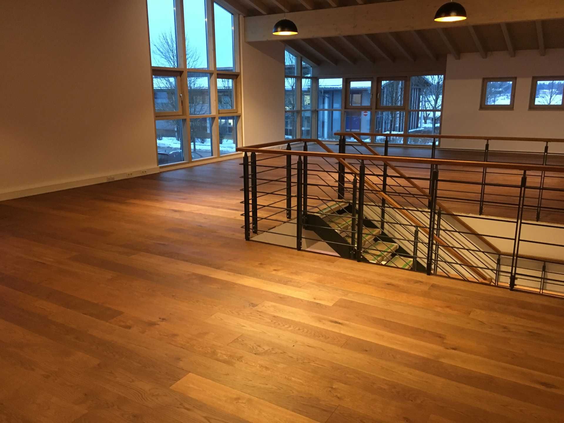 Ein leerer Raum mit einer Holztreppe und einem Metallgeländer