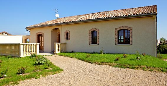 Maison neuve en enduit finition écrasé avec briquettes flammées autour