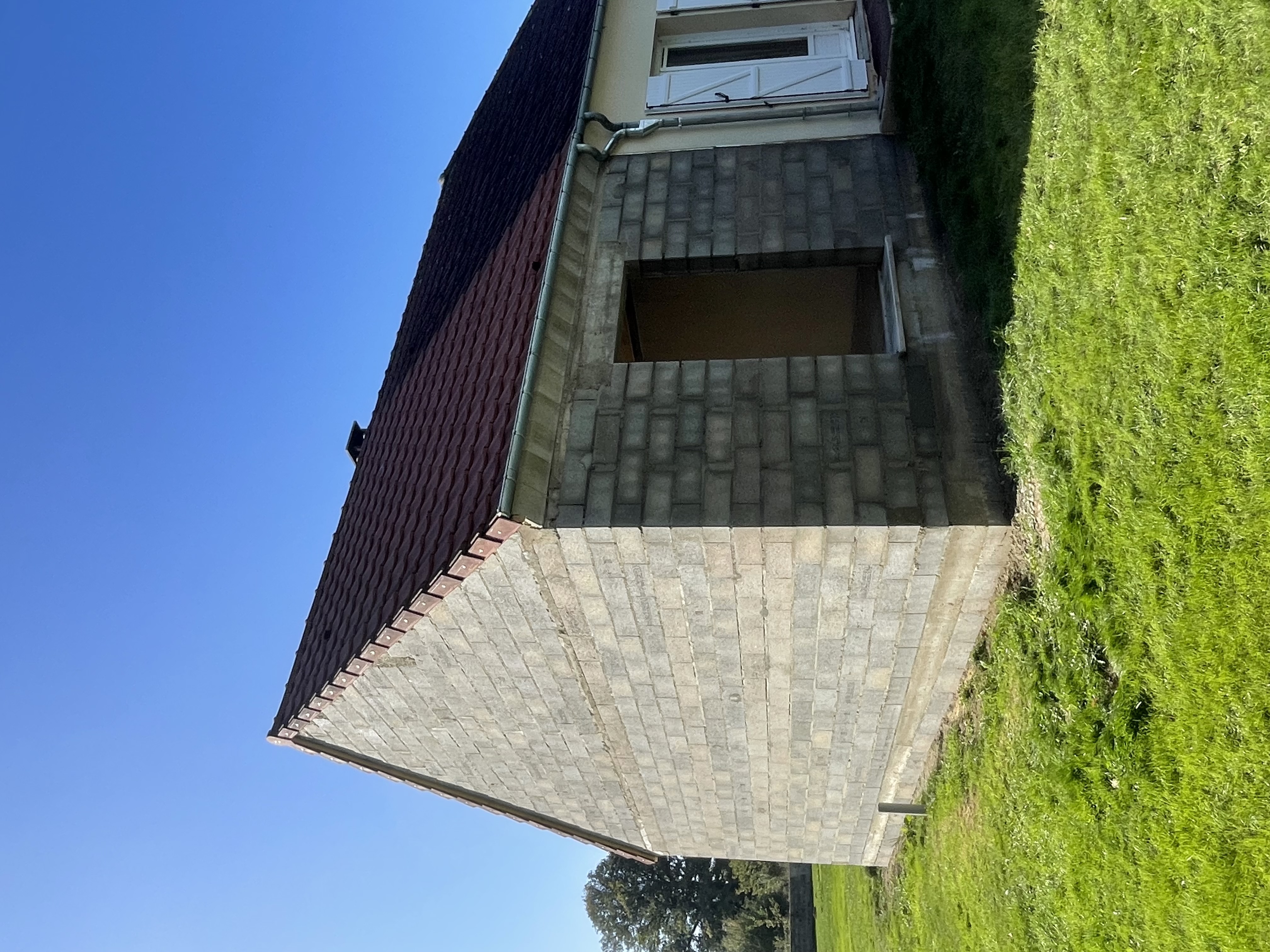 Maison partiellement construite avec charpente apparente au-dessus d'une structure bleue