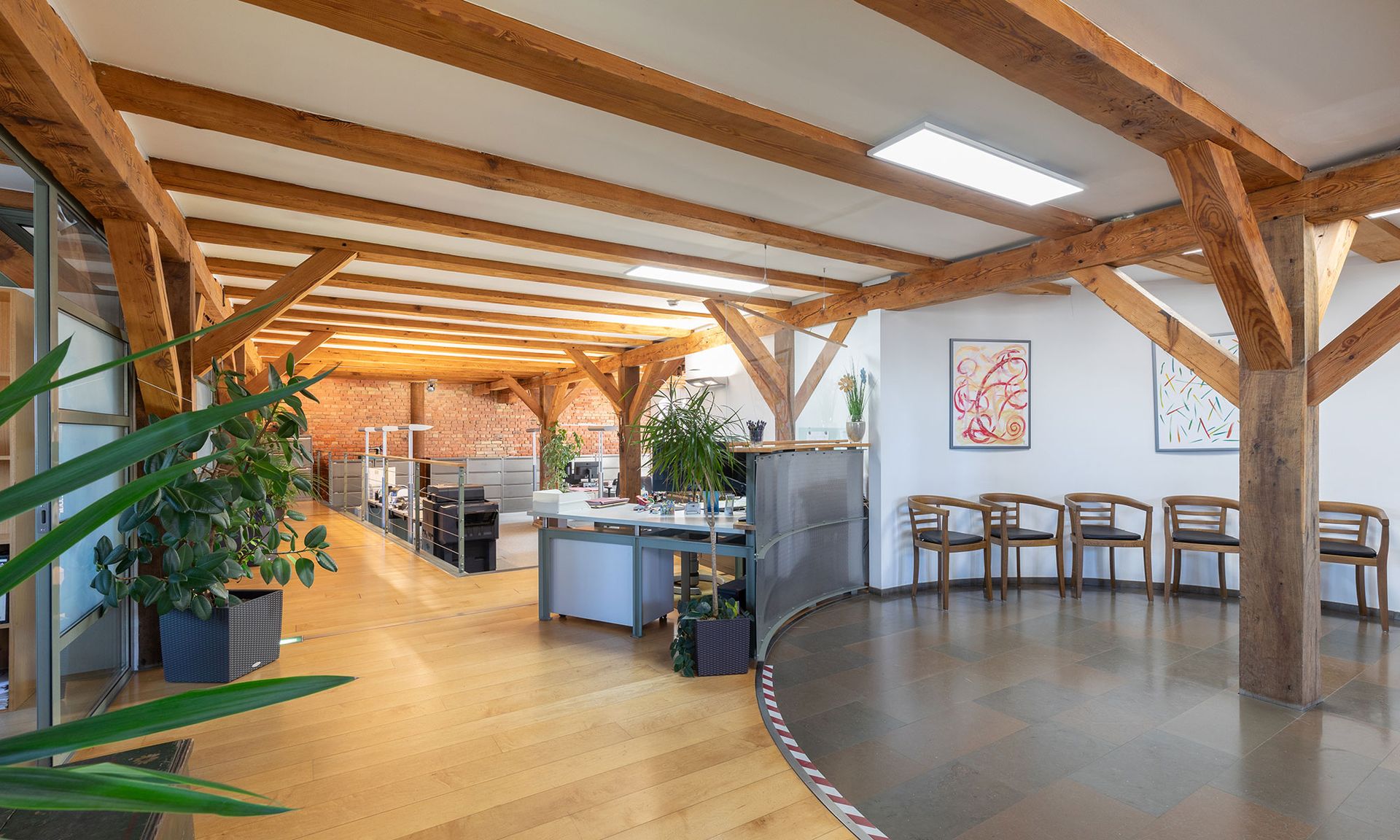 Ein großer Raum mit Holzbalken und Stühlen darin.