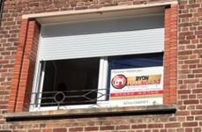 Fenêtre avec volet blanc semi-fermé