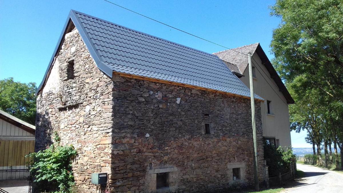 Toiture rénovée d'un bâtiment en pierres