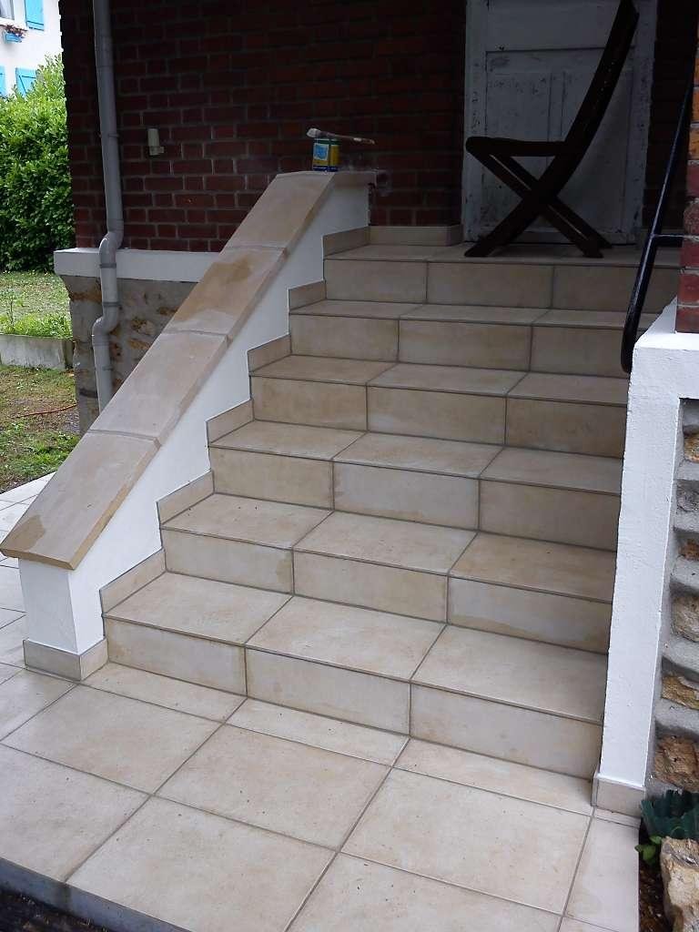 Escalier extérieur carrelé beige menant à un porche avec une chaise pliante noire.