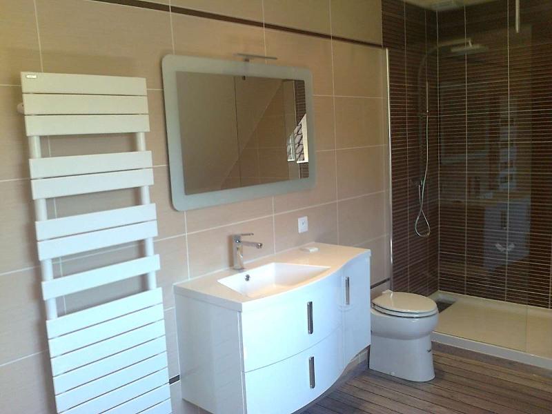 Meuble de salle de bain avec un miroir et un sèche serviettes