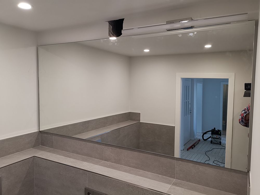 ein Badezimmerspiegel mit einer Tür dahinter