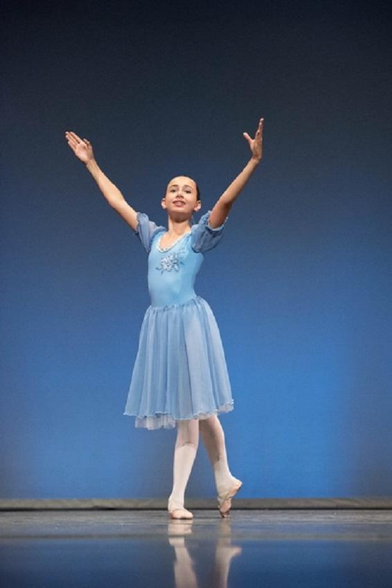 Danseuse en équilibre sur demi-pointe et port de bras