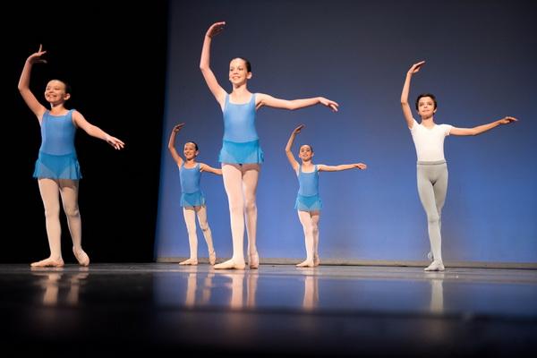 Enfant en costume de scène coloré exécutant un port de bras élégant