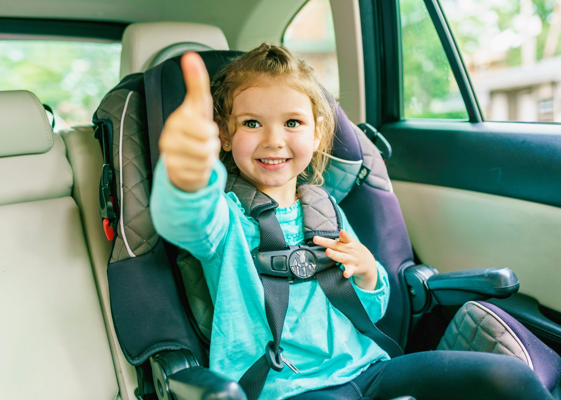 Un enfant dans un siège auto avec son pouce levé