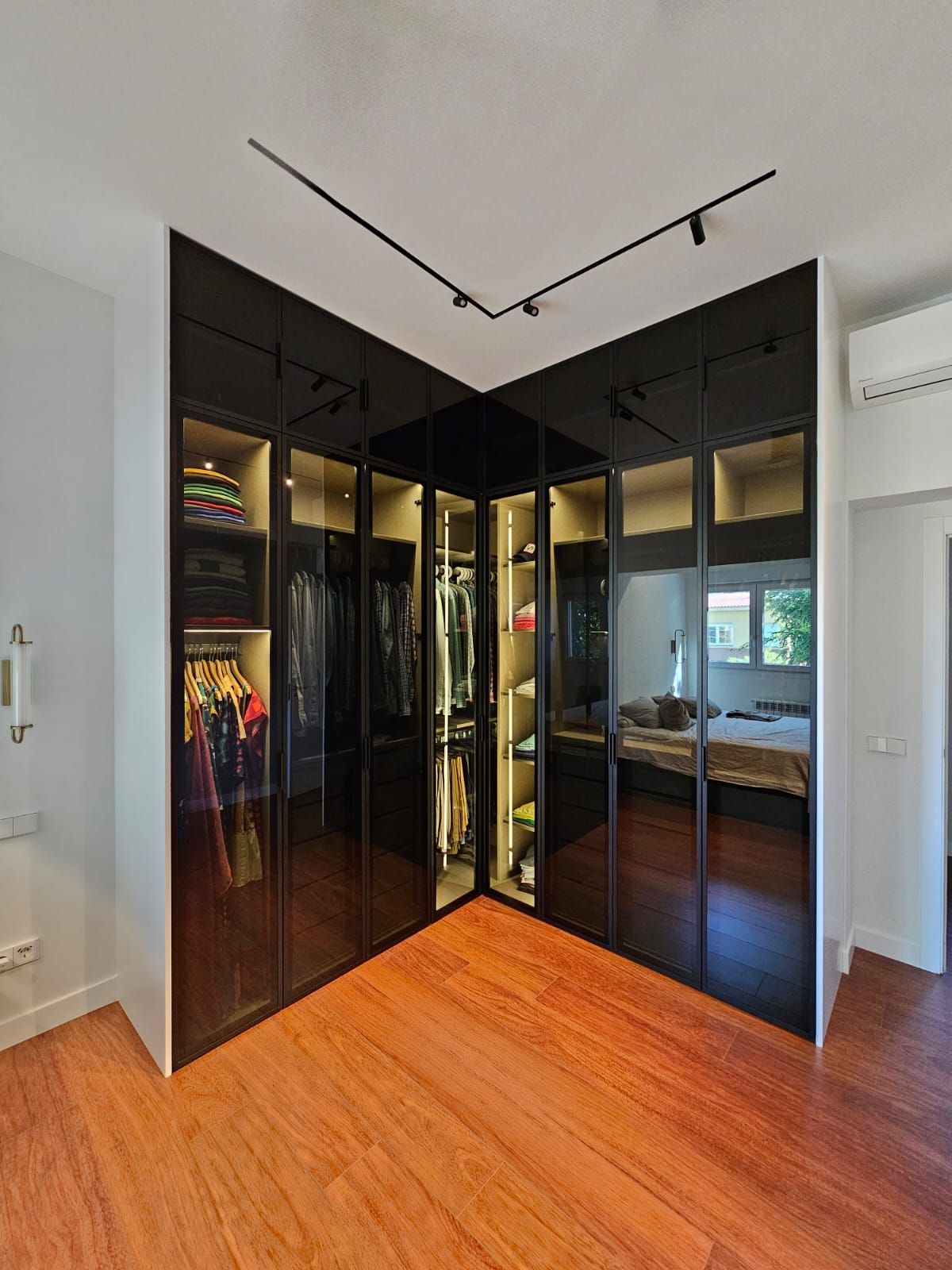 Un dormitorio con vestidor y una cama.