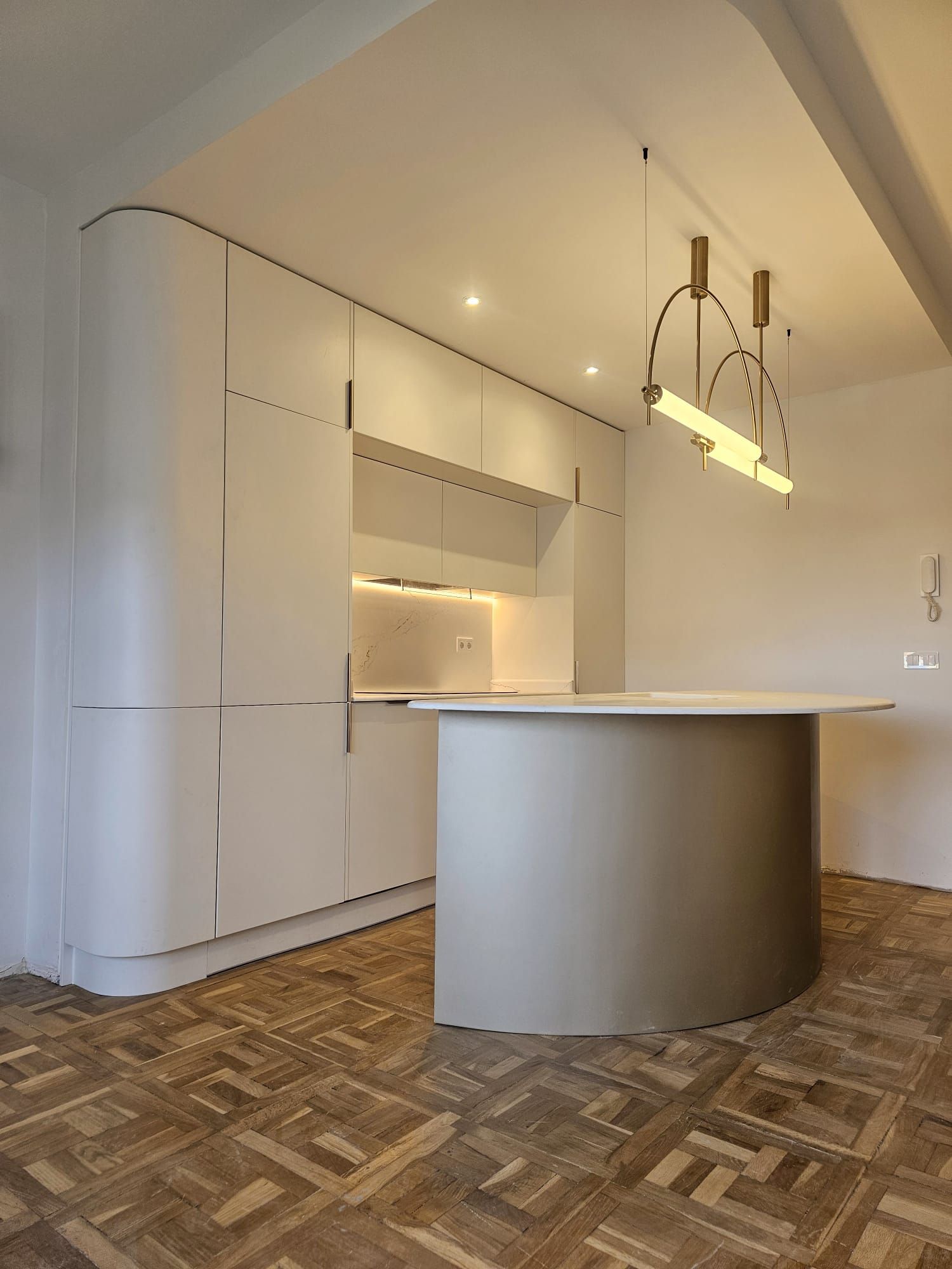 Una cocina con gabinetes blancos y piso de madera.