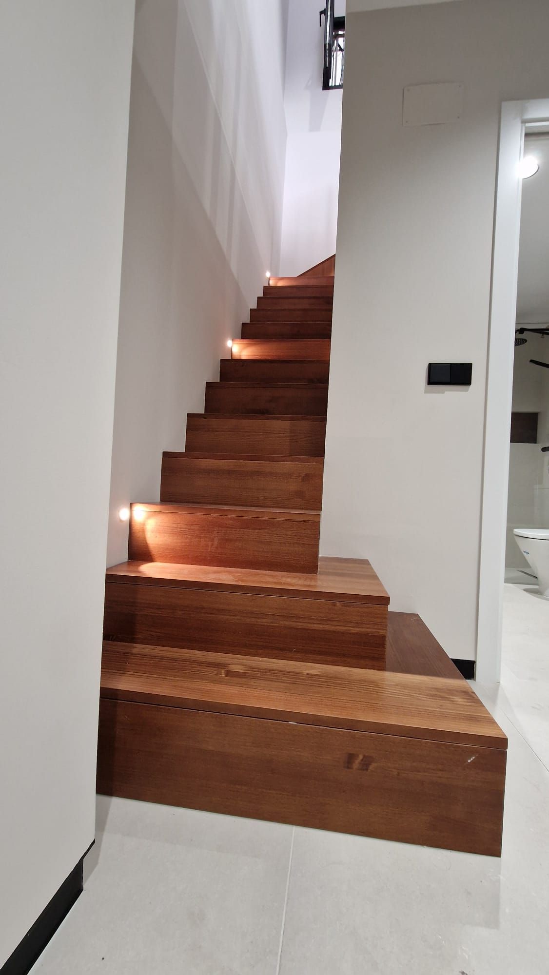 Una escalera de madera que conduce al segundo piso de una casa.
