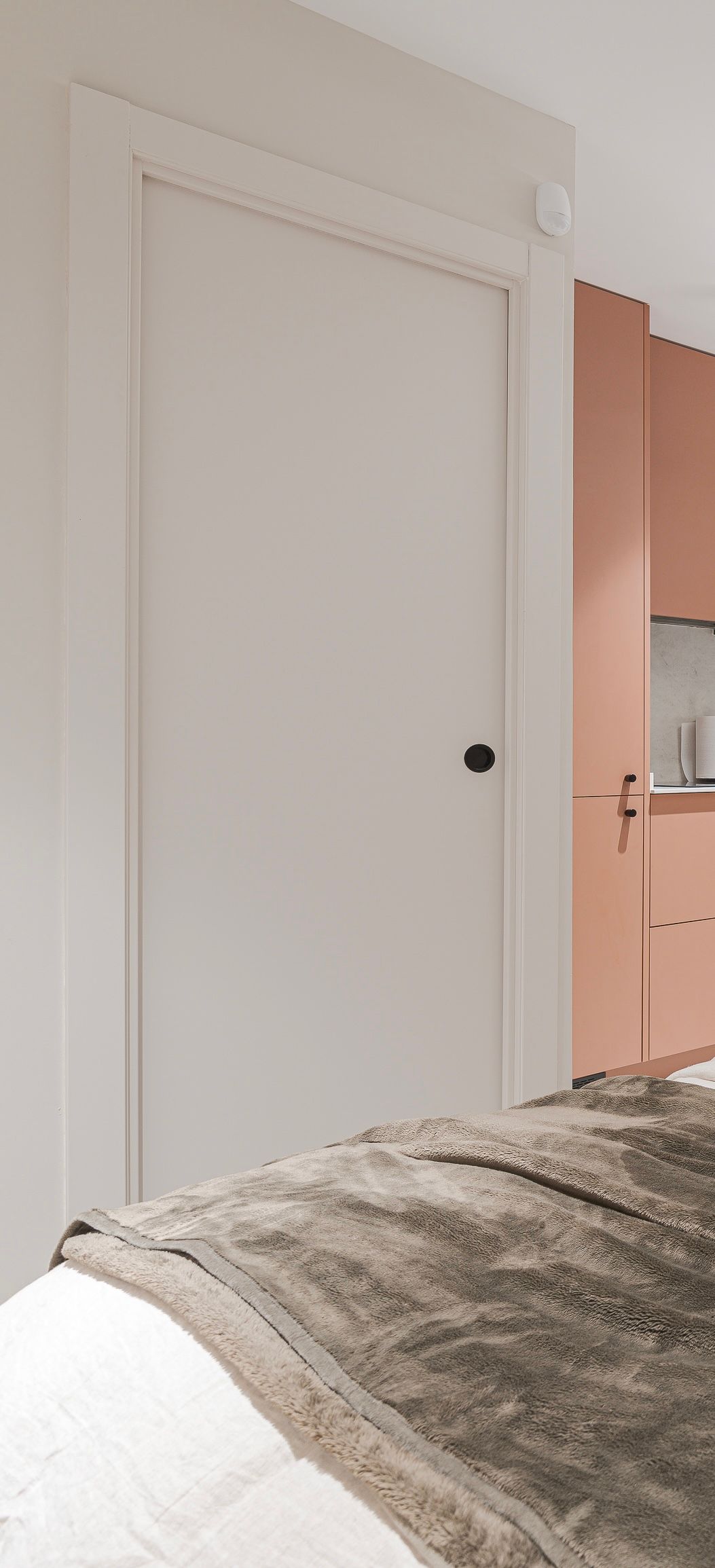 Un dormitorio con una cama y una puerta blanca.