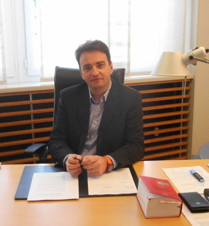 Photo de Maître Pierre SCHULTZ assis à un bureau avec un dossier sous les mains
