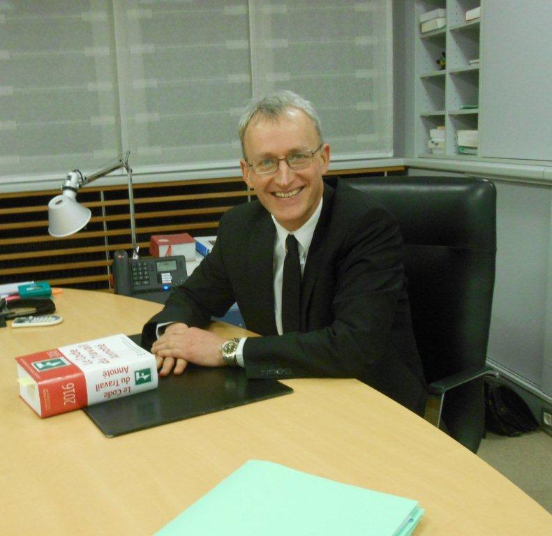 Photo de Maître Jean-Luc ROSSELOT souriant et assis à un bureau 