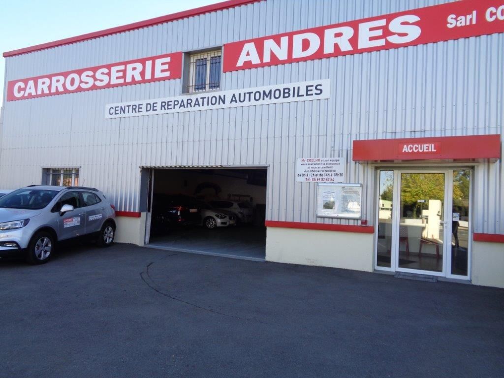 Extérieur de l'atelier de réparation automobile ANDRES Centre De Réparation Auto, avec un véhicule garé devant.