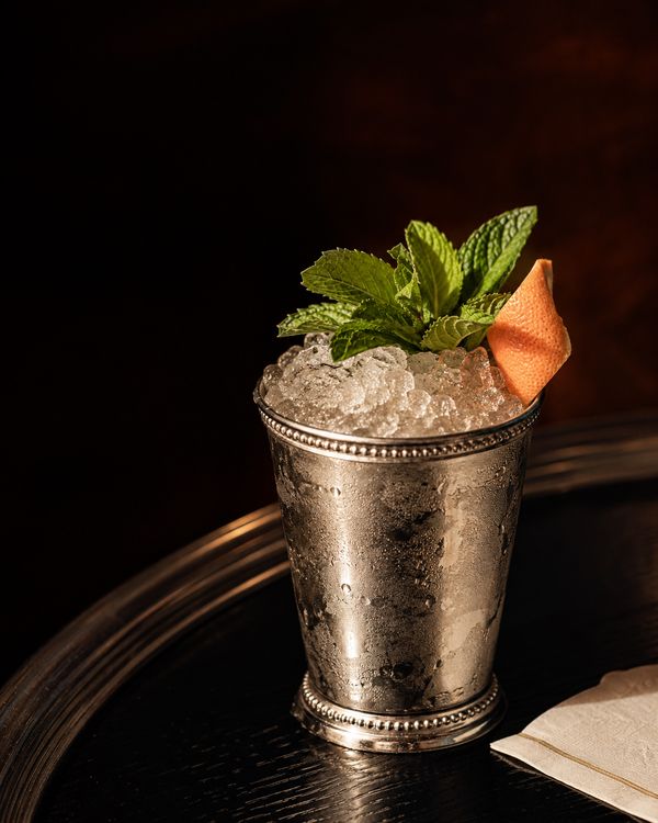 A mint julep packed with crushed ice and a generous bouquet of mint in a metal cup